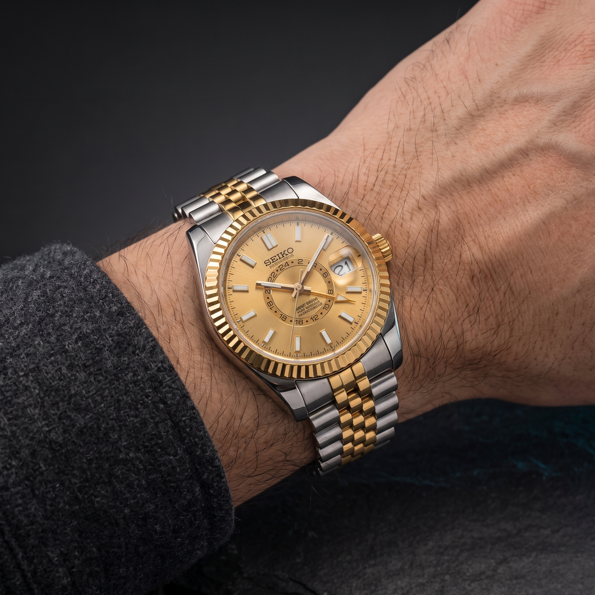 Reloj bicolor con esfera champagne y bisel estriado en la muñeca — colección SKY DWELLER de MODKEI